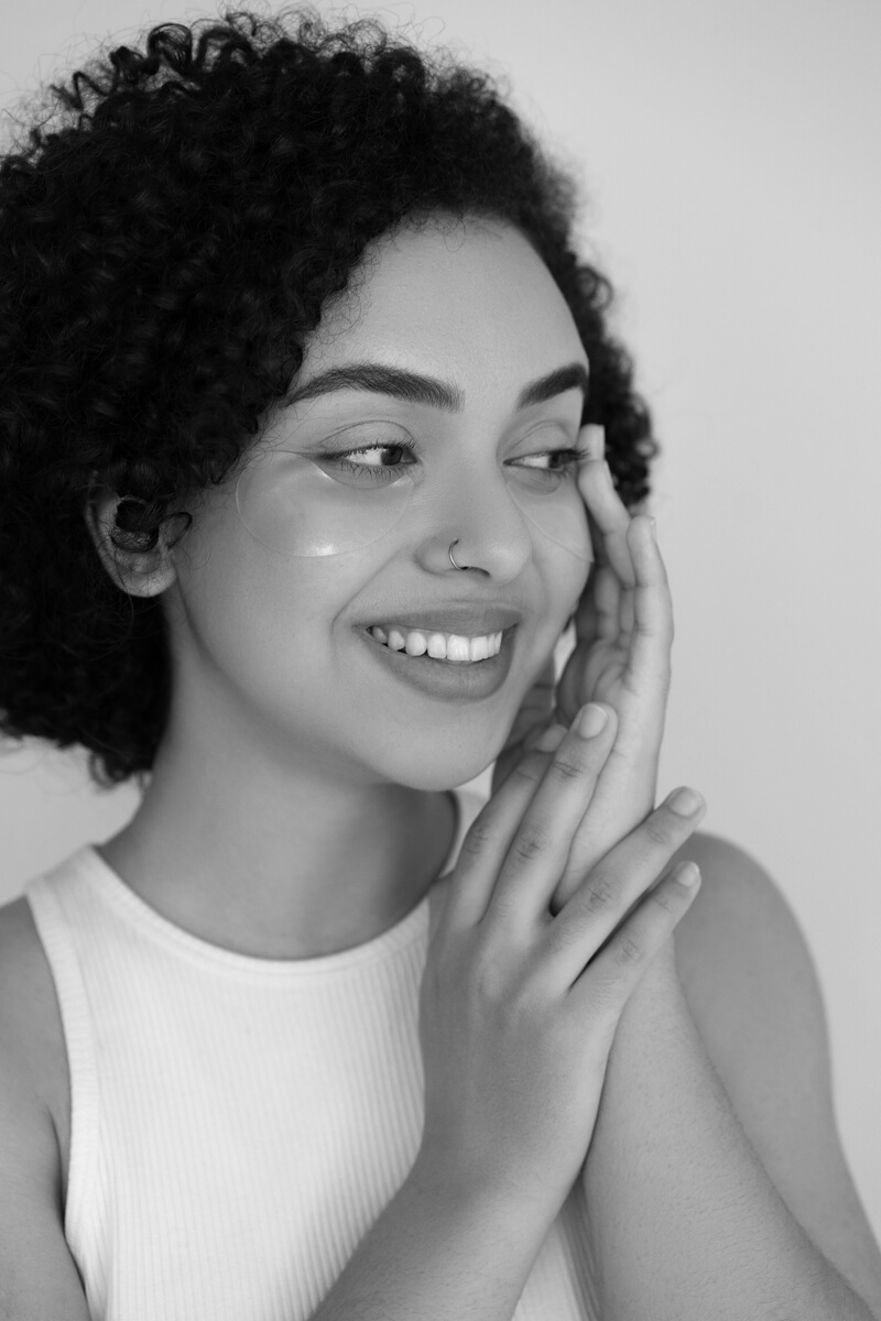 Woman in White Tank Top With Under Eye Mask